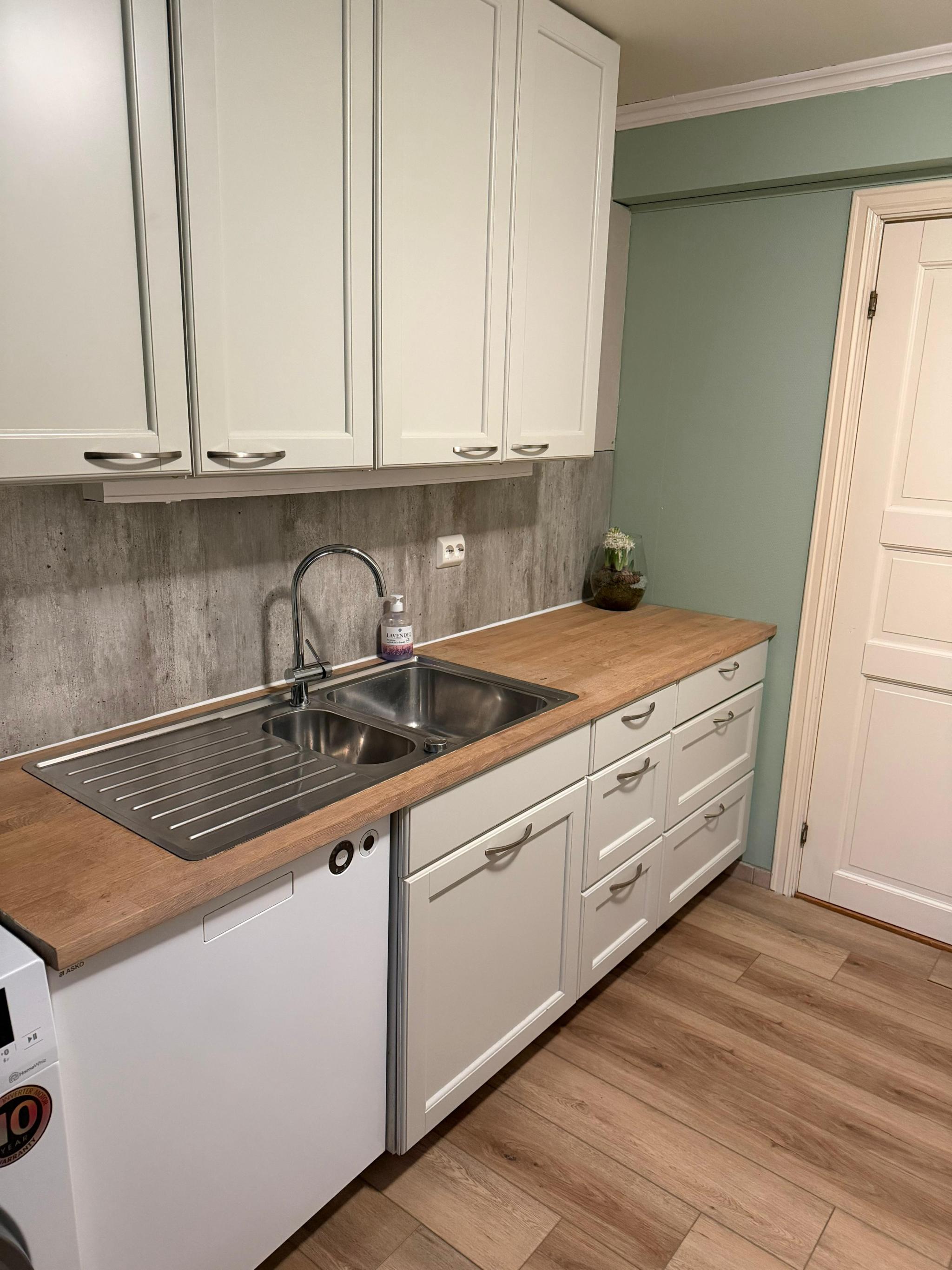 Kjøkken med oppvaskmaskin, komfyr og vaskemaskin